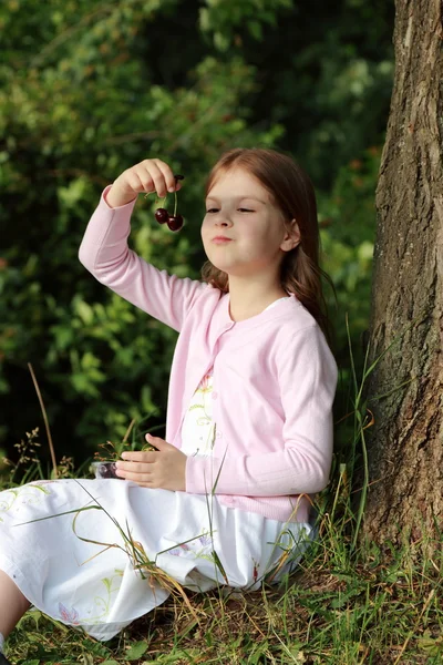 Liten flicka äter körsbär — Stockfoto