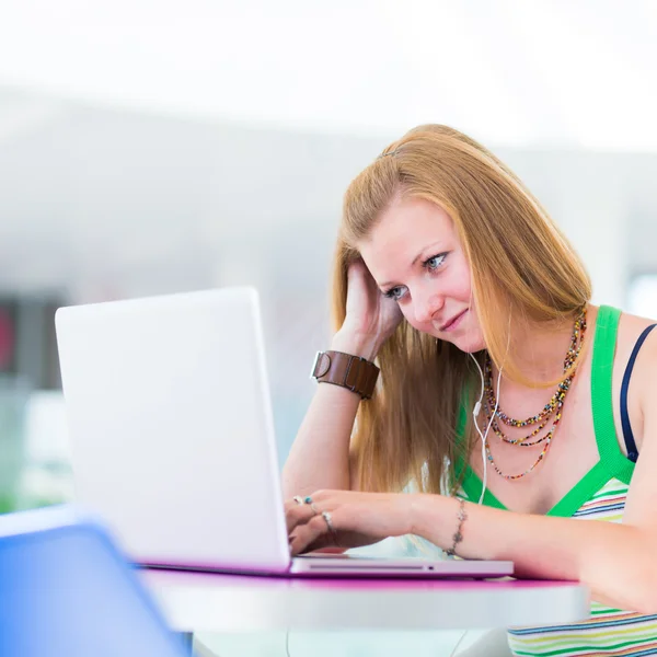 Ganska kvinnliga collegestudent arbetar på sin laptop — Stockfoto