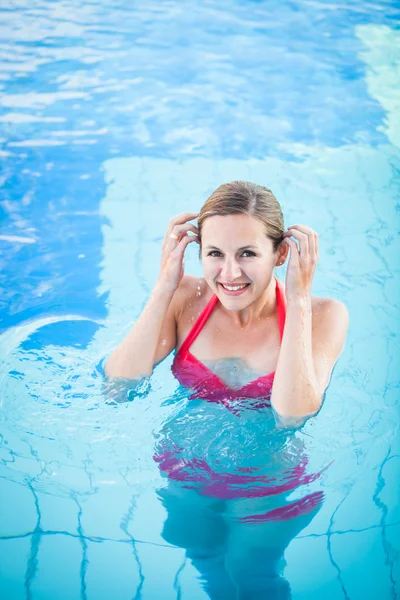 Portrait of a young woman relaxing in a swimming pool — Stock Photo, Image