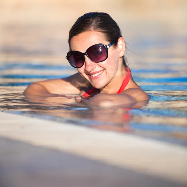Portrait of a young woman relaxing in a swimming pool Stock Image