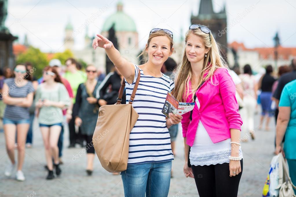 Two female tourists walking along the Charles Bridge