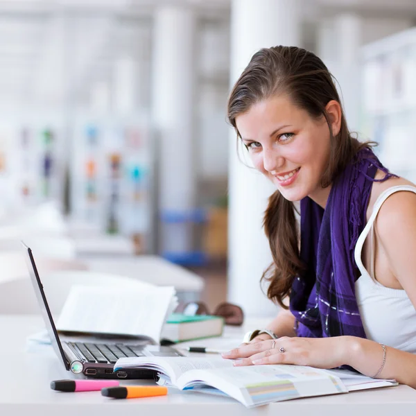 Ganska kvinnliga collegestudent som studerar på bibliotek — Stockfoto