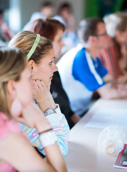 Mladá, hezká žena vysokoškolský student ve třídě plné — Stock fotografie