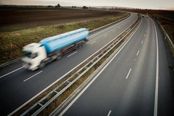 Tráfico por carretera - camión borroso en movimiento en una carretera — Foto de Stock