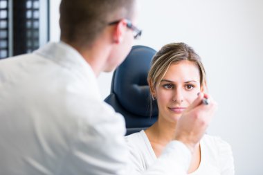 Optometri kavramı - yakışıklı genç adam gözlerini muayene yaptırıyor