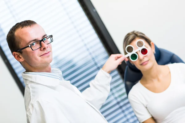 Concepto de optometría: joven guapo que examina sus ojos —  Fotos de Stock