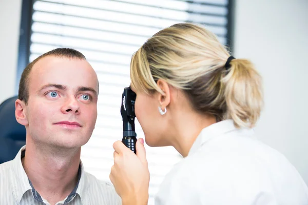 Optometria koncepcja - przystojny młody mężczyzna o jej oczy badane — Zdjęcie stockowe