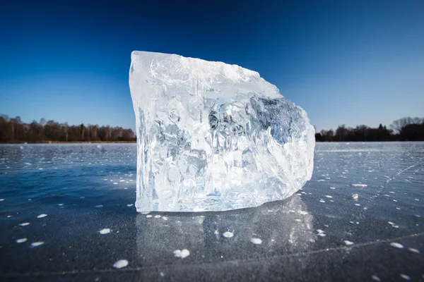 Freezing winter temperatures: block of ice lying on the surface — Stock Photo, Image