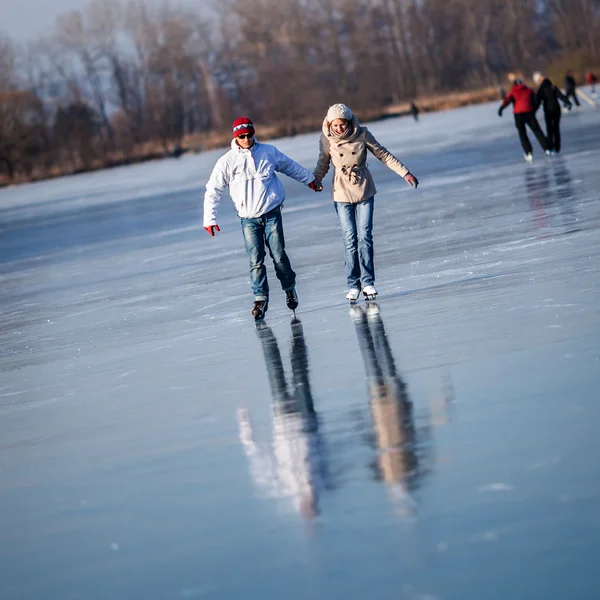 カップルのアイス スケート屋外で日当たりの良い素敵な池を冬の日 — ストック写真