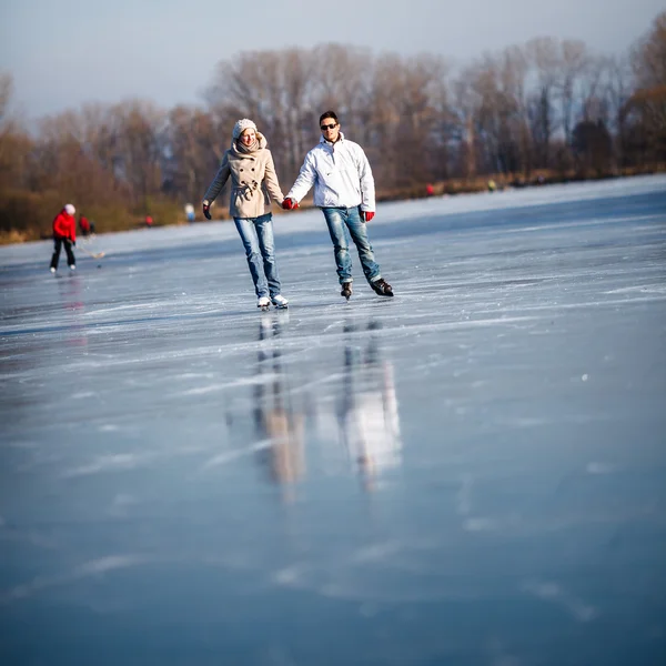 Couple ice skating outdoors on a pond on a lovely sunny winter day — Stock Photo, Image