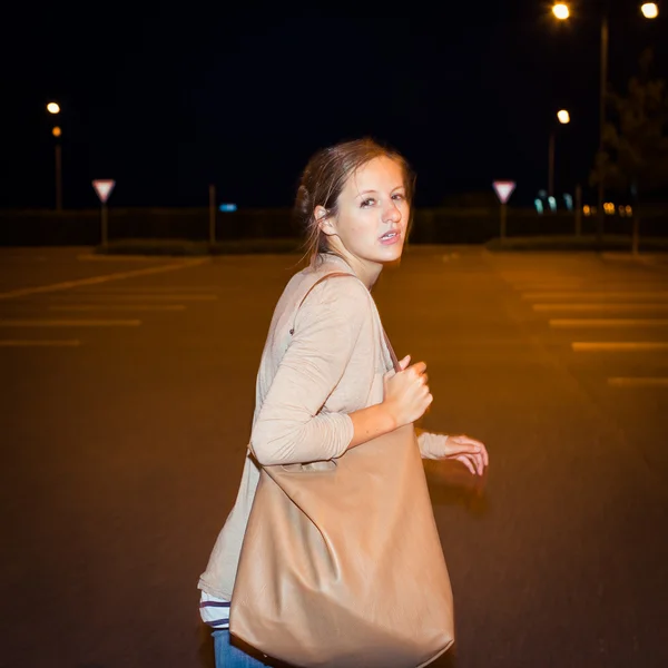 Налякана молода жінка біжить від свого переслідувача в покинутому парку — стокове фото