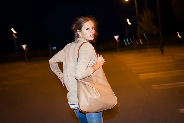 Scared young woman running from her pursuer in a deserted parkin — Stock Photo, Image