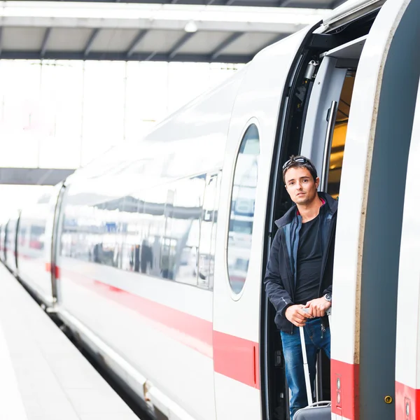Tågresor - stilig ung man med ett tåg — Stockfoto