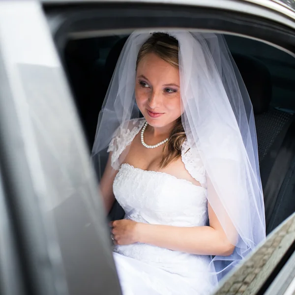 Retrato de una hermosa novia joven esperando en el coche en su wa —  Fotos de Stock