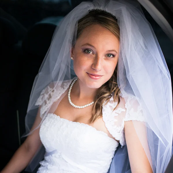 Retrato de una hermosa novia joven esperando en el coche en su wa — Foto de Stock