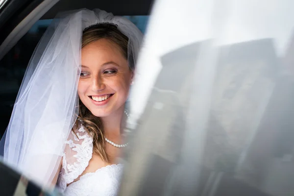 Retrato de uma bela jovem noiva esperando no carro em sua wa — Fotografia de Stock