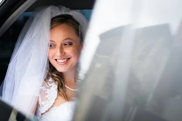 Retrato de una hermosa novia joven esperando en el coche en su wa —  Fotos de Stock