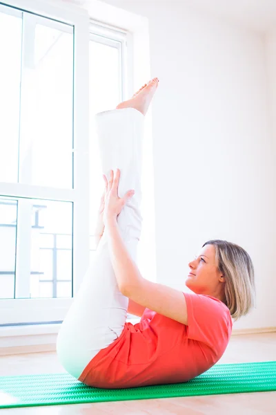 Genç ve güzel kadın, evde Yoga egzersiz yaparak — Stok fotoğraf