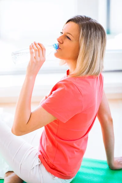 Mulher muito jovem refrescante durante o treino em casa — Fotografia de Stock