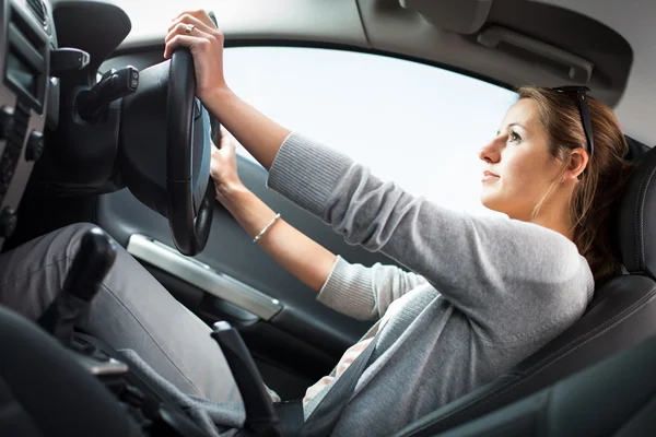 Hübsche junge Frau am Steuer ihres neuen Autos — Stockfoto