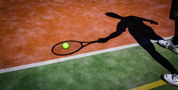 Sombra de um jogador de tênis em ação em um campo de tênis (conceptua — Fotografia de Stock