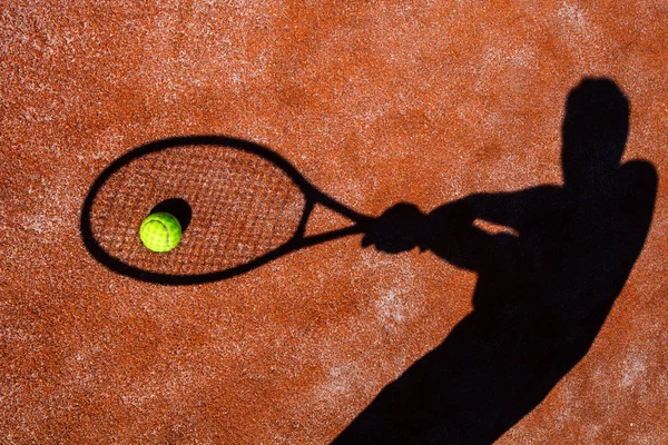 Schatten eines Tennisspielers in Aktion auf einem Tennisplatz (Konzept — Stockfoto