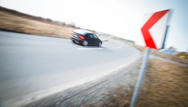 Conceito de tráfego: carro dirigindo rápido através de uma curva acentuada — Fotografia de Stock