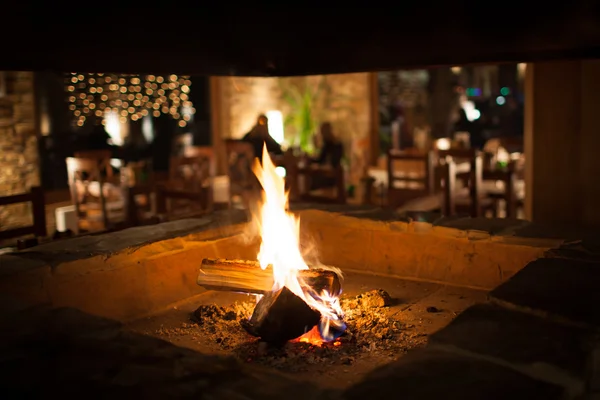 Cosy fireplace in a mountain chalet's warm, wooden interior Royalty Free Stock Photos