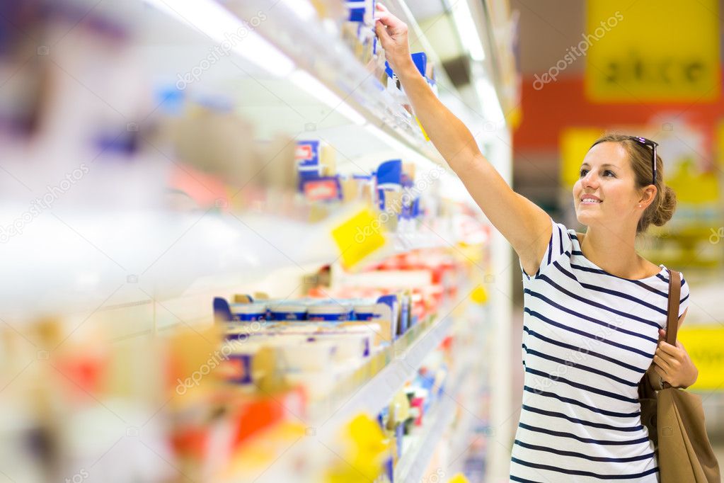 Beautiful young woman shopping for diary products at a grocery supermarket