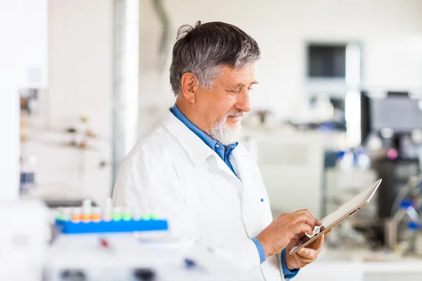 Cientista sênior usando seu computador tablet no trabalho — Fotografia de Stock