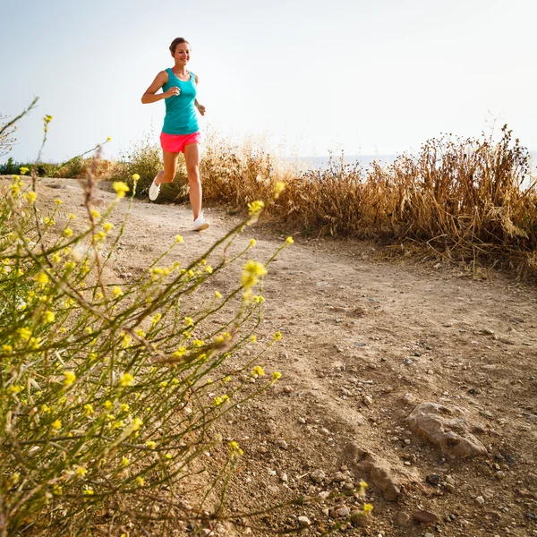 Junge Frau joggt abends an der Küste entlang — Stockfoto