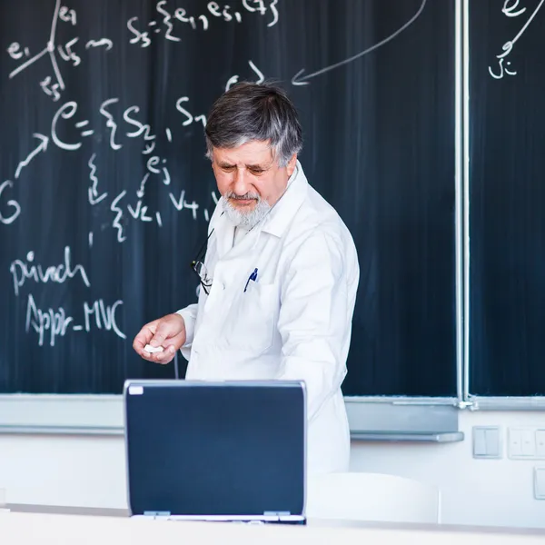 Seniorprofessor für Chemie schreibt auf der Tafel — Stockfoto