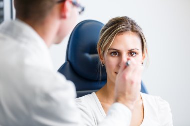 Optometri kavramı - genç ve güzel kadın gözleri muayene olması