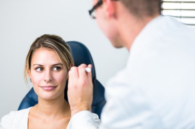 Optometri kavramı - genç ve güzel kadın gözleri muayene olması