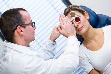 Optometri kavramı - genç ve güzel kadın gözleri muayene olması