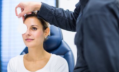 Optometri kavramı - genç ve güzel kadın gözleri muayene olması