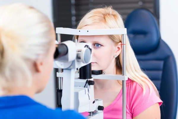 Concepto de optometría: paciente joven y bonita que se examina los ojos — Foto de Stock