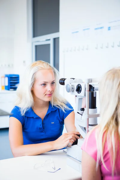 Concepto de optometría: paciente joven y bonita que se examina los ojos — Foto de Stock