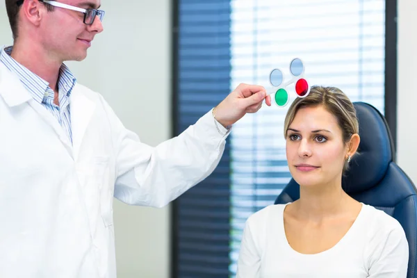 Optometrie concept - vrij jonge vrouw met haar ogen onderzocht — Stockfoto