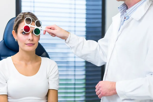 Concepto de optometría: mujer joven y bonita que examina sus ojos —  Fotos de Stock