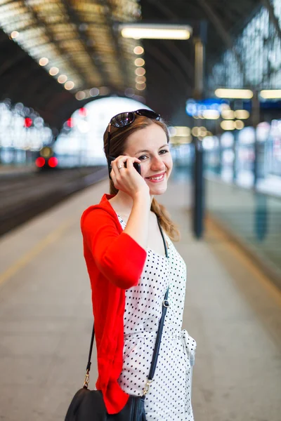 Pretty young woman at a train station — Stock Photo, Image