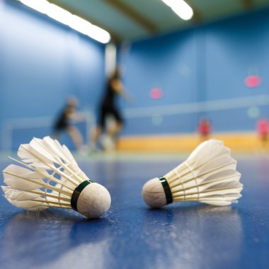 Badminton -, rakip oyuncular ön planda shuttlecocks ile badminton Mahkemeleri