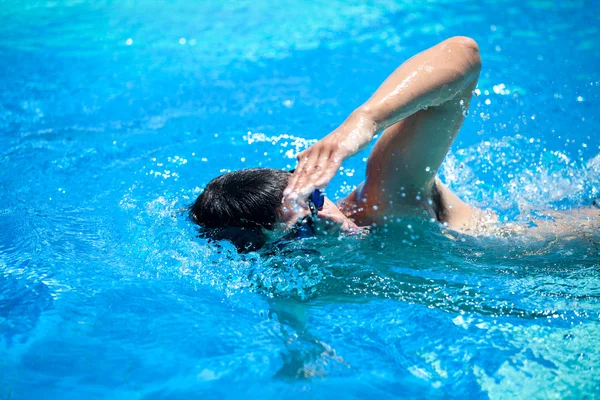 Joven nadando en la parte delantera, estilo libre en una piscina — Foto de Stock