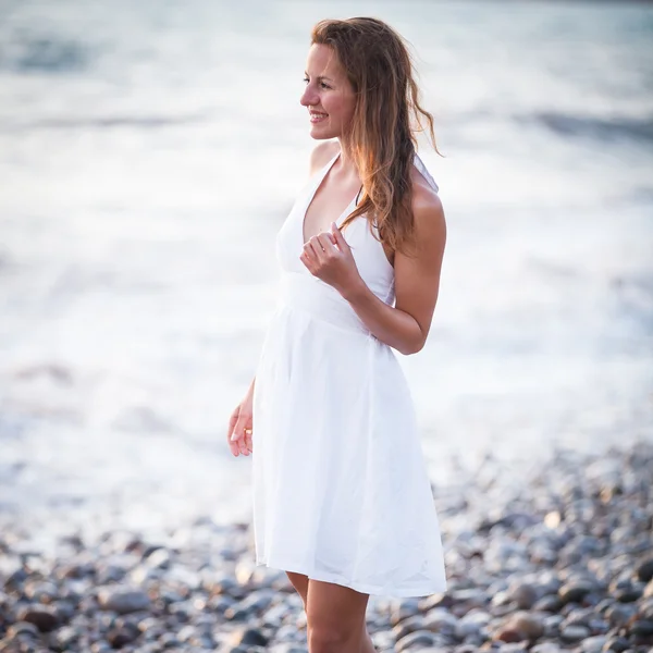 Молода жінка на пляжі насолоджується теплим літнім вечором — стокове фото