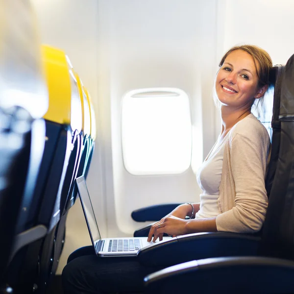 비행 중 비행기의 보드에 그녀의 노트북 컴퓨터에서 작업 하는 젊은 여자 — 스톡 사진