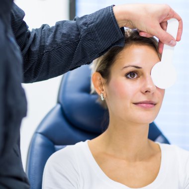 Optometri kavramı - genç ve güzel kadın gözleri muayene olması