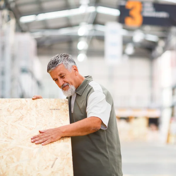 Hombre comprando madera de construcción en una tienda de bricolaje — Foto de Stock