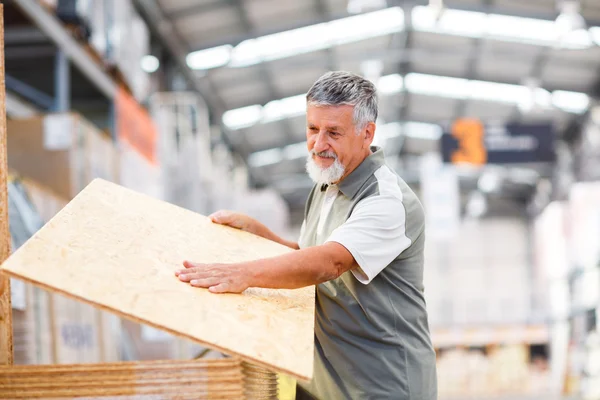Homem comprando madeira de construção em uma loja de bricolage — Fotografia de Stock