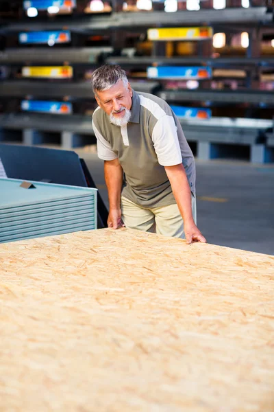 Homem comprando madeira de construção em uma loja de bricolage — Fotografia de Stock