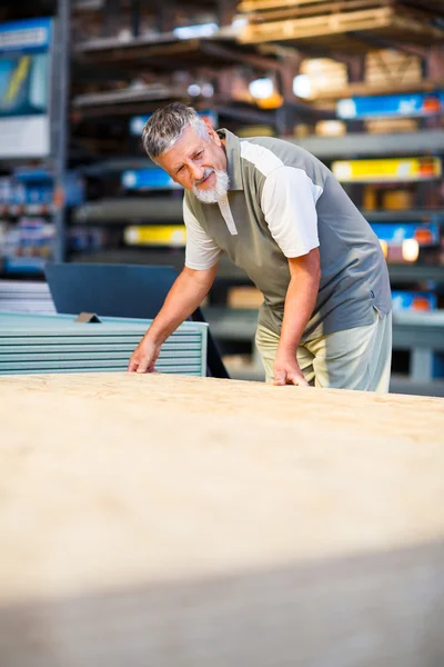 Człowiek kupujący drewno budowlane w sklepie z pamiątkami — Zdjęcie stockowe
